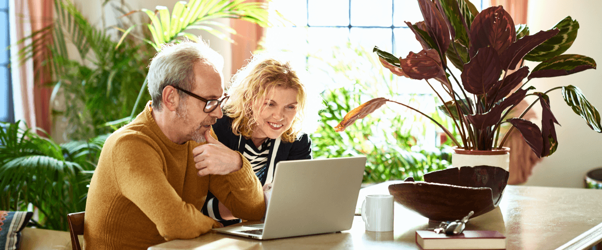 excited mature woman and her partner looking at computer